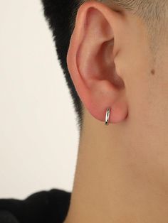 a close up of a person wearing a pair of ear piercings on their ears