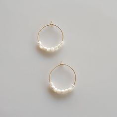 Introducing our exquisite Dainty Pearl Hoop Earrings, a harmonious blend of elegance and charm. Crafted with a touch of glamour, these Gold Hoop earrings effortlessly exude a minimalist appeal. Handmade using premium materials, including lustrous Mother of Pearl, these earrings are the epitome of refined beauty. Delicate and glimmering, they are the perfect accessory to elevate any look. Whether you're searching for a gift for Mom or a special Birthday gift for her, these Handmade Pearl Jewelry White 14k Gold Filled Hoop Earrings, White Small Hoop Pearl Earrings Single Earring, Nickel-free White Hoop Pearl Earrings, White Small Hoop Pearl Earrings With Ear Wire, White Small Hoop Pearl Earrings, White Pearl Small Hoop Earrings With Ear Wire, Dainty White Pearl Small Hoop Earrings, White 14k Gold Filled Hoop Jewelry, Handmade Minimalist Pearl Earrings