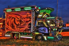 a semi truck decorated with neon lights and an image of a lion on the side