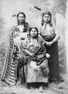 an old black and white photo of three native american women, one holding a baby