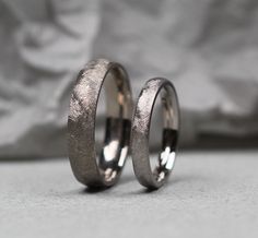 two wedding rings sitting next to each other