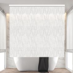 a white bath tub sitting next to a window covered in blind shades and blinds on top of it