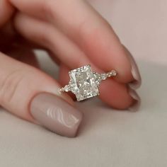 a woman's hand holding an engagement ring