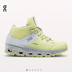 a pair of yellow and white shoes with the word on it's upper part