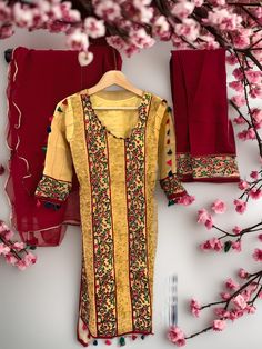 This stunning traditional South Asian suit for women is made from high-quality yellow haldi fabric, beautifully embroidered with intricate designs. The embroidery covers the entire suit, giving it an exquisite and sophisticated look. The suit is paired with a vibrant red salwar and a matching dupatta, also embroidered with delicate patterns. The combination of yellow and red creates a striking contrast, making this suit perfect for any occasion, from weddings and formal events to casual gatherin Yellow Resham Embroidery Sets, Mulmul Sharara With Embroidered Border For Navratri, Yellow Mulmul Sharara With Traditional Drape, Yellow Art Silk Kurta With Chikankari Embroidery, Navratri Sharara With Embroidered Border In Mulmul, Navratri Mulmul Sharara With Embroidered Border, Yellow Art Silk Anarkali Set With Chikankari Embroidery, Designer Yellow Kurta With Pallu, Designer Yellow Kurta With Pallu Detail