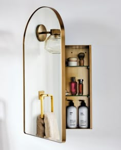 an open medicine cabinet with bottles and soaps on the shelf in front of it