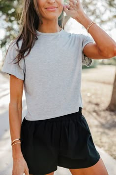 have you ever been standing in your closet wearing sweatpants or an athleisure outfit thinking “what top should i wear with this?!” meet your new go-to everyday cropped tee! made with athletic material you can pair with your high waisted workout leggings but still super cozy and looks great with joggers or denim as well! length is perfectly cropped without being too short. we recommend sizing up one size!! FINAL SALE: This item cannot be returned or exchanged Athleisure Outfits Disney World, Simple Workout Outfits, Modest Exercise Outfits, Feminine Athleisure Style, Spring Summer 2024 Outfits, Fitted Tee Outfit, Sporty Chic Outfits Summer, Modest Athletic Outfits, Athleisure Outfits Shorts