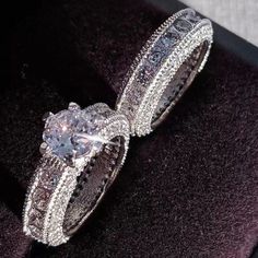 an engagement ring with two rows of diamonds in it on top of a velvet box