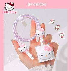 the hello kitty earphones are being held by a woman's hand with pink nail polish