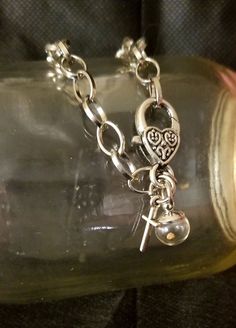 "Faith Bracelet - Mustard Seed and Cross with Heart Clasp  (Matthew 17:20) Beautiful circle loop chain bracelet with gorgeous heart lobster clasp,  plus two hanging charms:  a mini-globe with a mustard seed within and a small silver-toned cross.  Details:  Bracelet: *8.26 inches/ 21cm-22cm, circle link 10.5x8mm, clasp 25x14mm.   *modifiable lengths/links  Silver toned, lead free, alloy metal loop chain.  Mustard Seed Pendant Charm: A real mustard seed is within glass globe.   Globe size is 10mm Adjustable Metal Charm Necklace With Heart Charm, Adjustable Heart-shaped Metal Charm Bracelet, Valentine's Day Metal Charm Necklace With Lobster Clasp, Metal Dangle Charms With Adjustable Chain, Metal Heart Dangle Charms, Metal Heart Charm Dangle, Metal Dangle Heart Charms, Metal Heart Charm Dangle Charms, Silver Charm Bracelet With Heart Charm For Friendship