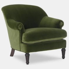 a green velvet chair with wooden legs