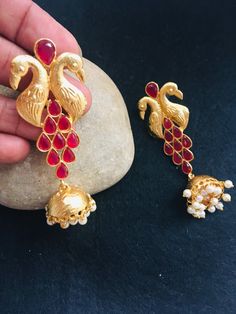 "These are purely handmade jumiki earrings in Gold . A gold jumki with emerald green stones . A very unique hand crafted earrings  Available in 1. Ruby red stone & gold jhumka/ jumki 2. Emerald green stone & gold jhumki / jumkha earrings  These are an authentic Indian traditional earrings that could be worn by both traditional and an western attire. This Unique jewellery is designed and crafted at Abi CreatioNzs Abi CreatioNzs is the place for anyone who Is in lookout for a latest trend with an ethnic touch.  We at Abi CreatioNzs offers a great range of Indian Ethnic jewellery's. We are strongly committed to  providing our customers  some uniquely handcrafted products with utmost satisfaction.  Note: The product shipped will be same as shown in the picture however, actual colours may vary Dangle Latkans Earrings For Puja, Latkan Dangle Earrings For Puja, Temple Jewelry Style Jhumkas For Party, Temple Jewelry Jhumkas For Party, Temple Jewelry Style Party Jhumkas, Bollywood Style Handmade Jhumkas For Festive Occasions, Handmade Bollywood Jhumkas Drop Earrings, Handmade Bollywood Drop Jhumkas, Handmade Bollywood Dangle Jhumkas