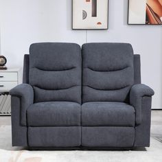 a gray reclining couch sitting on top of a white rug