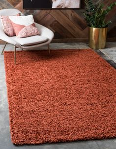 an orange rug in front of a wooden wall