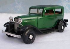 an old model green truck is parked in the snow