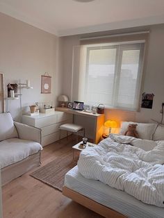 a bed room with a neatly made bed next to a chair and desk in front of a window