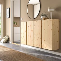 a living room with a large mirror on the wall next to a wooden cabinet and rug