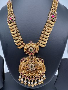 Peacock Pendent Mango Links Red Stone Nakshi Short Necklace with Matching EarringsColor : GoldenSize : Necklace Length : 24 Inches; Earring Length : 2.5 InchesStones : CZ Red Stone Pearls Traditional Peacock Pendant Temple Necklace, Multicolor Peacock Design Temple Necklace, Multicolor Peacock Design Necklace For Puja, Traditional Kundan Necklace With Peacock Pendant, Festive Peacock Design Jewelry, Festive Kundan Peacock Pendant Necklace, Multicolor Peacock Design Temple Necklace For Festivals, Multicolor Peacock Temple Necklace For Festivals, Traditional Necklace With Peacock Design For Celebration