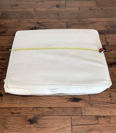 a white pillow with a yellow cord on it