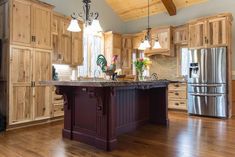 a large kitchen with wooden cabinets and an island in the middle, along with stainless steel appliances