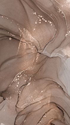 an aerial view of sand and water with white dots on the bottom right corner, in brown tones