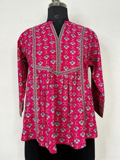 Fuchsia Pink Printed Tunic Top /Kurti For Women Short Kurta For Women- This outfit is made with the finest Pure Cotton of India. The set contains : 1  Kurti Kurti: Fuchsia printed empire top kurti/tunic comes with a mandarin collar neck ,sequinned  details, flared waist and straight hem.  Sleeve length :  3/4 Sleeves   Material : Kurti :  Pure Cotton Fabric Care : Machine wash Front length : 28 inches Please see the photo section  to choose a perfect size for yourself.  *Please note the color of Festive Pink Tunic, Festive Pink Straight Kurta Blouse, Traditional Pink Tunic For Festive Occasions, Pink Long Sleeve Tops For Festive Occasions, Pink Long Sleeve Festive Tops, Festive Cotton V-neck Top, Transitional Pink Kurta With Printed Motifs, Straight Kurta Tops For Navratri Festive, Pink Kalamkari Print Kurta For Diwali