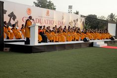 a large group of people in orange robes are on stage with microphones and speakers