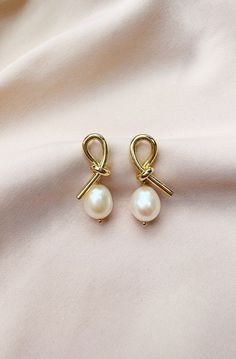 "The Elise Earrings  For pierced ears - order comes with stud earring backs + 14k Gold- filled earring with knot detail + Genuine, freshwater baroque pearls ABOUT BAROQUE PEARLS Baroque pearls are some of the most fascinating organic gems available on the jewelry market. Baroque refers to all pearls that aren't perfect spheres. In other words, if it isn't perfectly round, it is considered a baroque pearl. These imperfections result in pearls of varied and irregular shapes and sizes, sometimes wi Affordable Pearl Drop Earrings, Bridesmaid Earring, Bridesmaid Pearl Earrings, Earring Pearl, Jewelry Market, Pearl Drop Earrings Gold, Earrings Hanging, Bridal Earring, Bridesmaid Pearls