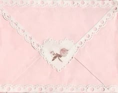 a pink envelope with a heart and flower on it's front flap is shown