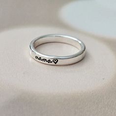 This is a sweet classic sterling silver ring that celebrates the unique bond between a mom and her child! This custom hand-stamped ring is as adorable as it is meaningful, with "mama" or your child's name beautifully stamped one letter at a time onto a shiny silver band, creating a personalized and whimsical keepsake that Mom will cherish. The sterling silver band is crafted with love and care, ensuring a comfortable fit for Mom's finger. The band is designed to be stylish and eye-catching, with Mama Ring, Crown Decor, Stamped Ring, Hand Stamped Ring, Silver Stacking Rings, Mom Birthday, Mom Birthday Gift, Sterling Silver Bands, Stacking Ring