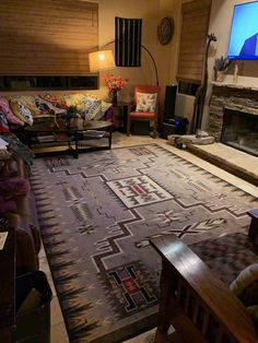 a living room filled with furniture and a flat screen tv mounted on a wall above a fire place