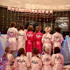 a group of women in pink robes standing next to each other with their names on them