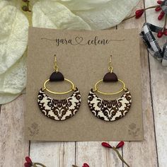 Our very own namesake earring. Wood etched with a beautiful victorian style pattern, mounted on gold-colored hoops, hardware and genuine leather. Choose from brown or black leather! Elegant Brown Brass Earrings, Elegant Hand Tooled Brown Jewelry, Elegant Hand-tooled Brown Jewelry, Bohemian Brown Pierced Hoop Earrings, Brown Brass Earrings, Brown Brass Hoop Earrings As Gift, Gift Brown Brass Hoop Earrings, Bohemian Brown Hoop Earrings Gift, Bohemian Brown Hoop Earrings For Gift