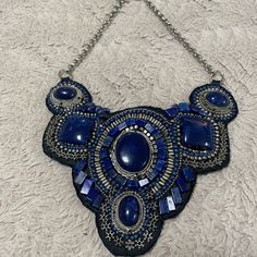 Style: 570139517 Amazing Beaded Detail Makes This Statement Necklace Stand Out. Swirled Simulated Stones Are Surrounded By Tiny Beads To Create This Show-Stopping Piece. Adjusts From 24"-28". 45% Metal, 20% Resin, 15% Other And 10% Polyester. Imported. Blue Adjustable Bib Necklace With Round Beads, Adjustable Blue Bib Necklace With Colorful Beads, Bead Embroidery Jewelry Necklaces, Blue Bohemian Chrysocolla Beaded Necklace, Blue Beaded Multi-strand Crystal Necklaces, Blue Multi-strand Beaded Crystal Necklace, Chicos Jewelry, Beautiful Beaded Jewelry, Necklace Stand