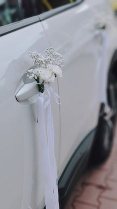 a bouquet of flowers tied to the side of a white car