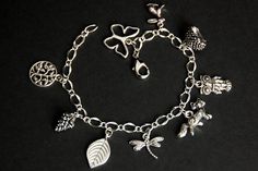 A collection of silver plated crochet themed charms have been dispersed around a shimmering silver plated bracelet chain in this handmade charm bracelet. This crochet charm bracelet is then completed with a lobster clasp and a 1/2 inch of chain at the end for adjustable sizing. Charms in this bracelet include a tree charm, pinecone charm, leaf charm, dragonfly charm, fox charm, owl charm, porcupine charm, rabbit charm, and butterfly charm. ● Sizing ● To determine your bracelet size, do a snug me Handmade Sterling Silver Bracelet For Gift, Sterling Silver Vintage Charm Bracelet For Gift, Sterling Silver Vintage Charm Bracelet Gift, Sterling Silver Vintage Charm Bracelet As A Gift, Handmade Alloy Bracelets Perfect As Gifts, Silver Charm Bracelet With Vintage Charm As A Gift, Handmade Alloy Bracelets As Gift, Sterling Silver Dangle Charm Bracelet With Vintage Charm, Handmade Silver Metal Charms