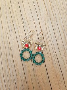 These adorable Christmas Wreath Earrings are Handmade with Emerald Green and Red Swarovski Crystal Bicone Beads and Tierra Cast, Lead-Free Pewter Bow Beads. 14K Gold Filled Ear Wire by Tierra Cast has been used. Meticulously wire wrapped with Tarnish Resistant 14k Gold Plated Wire. Charming yet attractive Holiday Earrings. You just have to pick up a pair of these delightful Holiday Earrings. Great gift for girls and women who love Christmas Jewelry. Earring Detail / Measurements * 14k Gold Fille Handmade Jewelry For Holiday Celebration, Handmade Holiday Jewelry For Celebration, Handmade Jewelry For Christmas Celebration, Round Earrings For Christmas Anniversary, Handmade Round Jewelry For Christmas, Handmade Round Christmas Jewelry, Handmade Round Christmas Earrings, Christmas Jewelry Gift With Matching Earrings, Nickel-free Jewelry For Festive Holidays