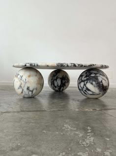 three marbled objects sitting on top of each other in front of a white wall