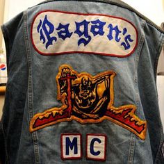 the back of a denim jacket with embroidered patches on it, and an image of a skeleton