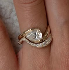 a woman's hand with a gold ring on it and a white diamond in the middle