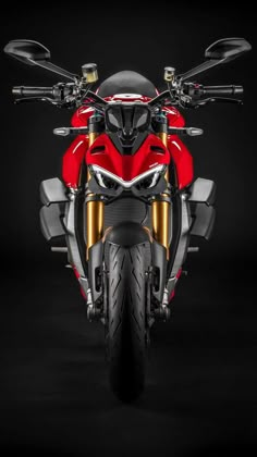 the front end of a red motorcycle on a black background