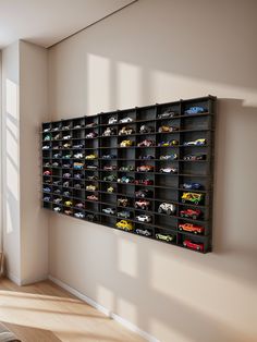 a wall mounted toy car storage unit in a living room next to a large window