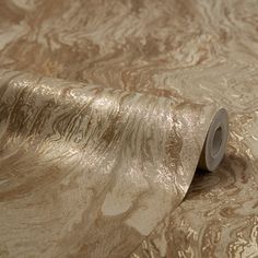 a roll of metallic foil sitting on top of a table next to a roll of toilet paper