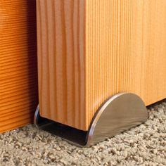 a close up view of the corner of a wood paneled wall with a metal base