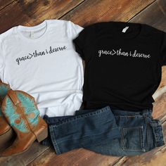 two t - shirts with the words grace and hope on them sitting next to jeans