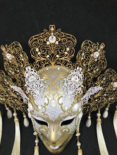 Venetian Mask for decoration - Traditional and original papier-mache Venetian mask, handmade and decorated with metal insert, gold-leaf and glitters, enriched with Swarovski crystals. Dimension::Hight 35cm,width 28cm Decoration only,not wereable All our masks are handmade paper-machè masks made in Venice. Our decorators use techniques typical of the Venetian tradition such as stucco, acrylics, gold and silver-leaf, macramè, passementerie, glitters and crequelè to offer you a wide range of origin Gold Fantasy Headpiece For Carnival, Gold Headpieces For Costume Party And Carnival, Gold Venetian Mask For Party, Venetian Gold Mask For Party, Gold Venetian Masks For Party, Gold Venetian Party Mask, Gold Fantasy Mask For Costume Party, Gold Fantasy Masquerade Mask For Party, Gold Fantasy Masquerade Mask For Costume