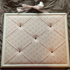 an upholstered photo frame with a bow on top