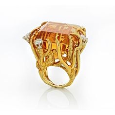 Transport yourself back to the glamorous era of the 1970s with our exquisite 18K Yellow Gold Citrine and Diamond Ring. This stunning piece captures the essence of the time, exuding elegance and sophistication.At the heart of this ring is a breathtaking 117-carat citrine, radiating warmth and capturing the golden hues of the sun. The vibrant gemstone is beautifully complemented by approximately 2 carats of dazzling diamonds, which dance and sparkle with every movement. The diamonds frame the citr Luxury Yellow Open Ring Jewelry, Exquisite Evening Gemstone Rings, Exquisite Yellow Gold Rings For Evening, Exquisite Gold Rings For Evening, Luxury Evening Rings With Gemstone, Unique Yellow Gold Topaz Ring For Formal Occasions, Elegant Citrine Rings For Formal Occasions, Luxury Gold Topaz Ring, Yellow Gold Gemstone Rings For Evening