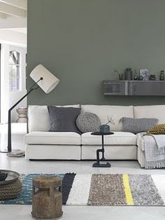 a living room with a white couch and green walls in the background is an instagram page