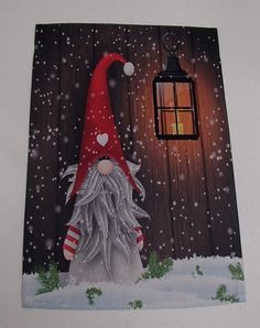 a christmas card with an image of a gnome in front of a lantern on a snowy night